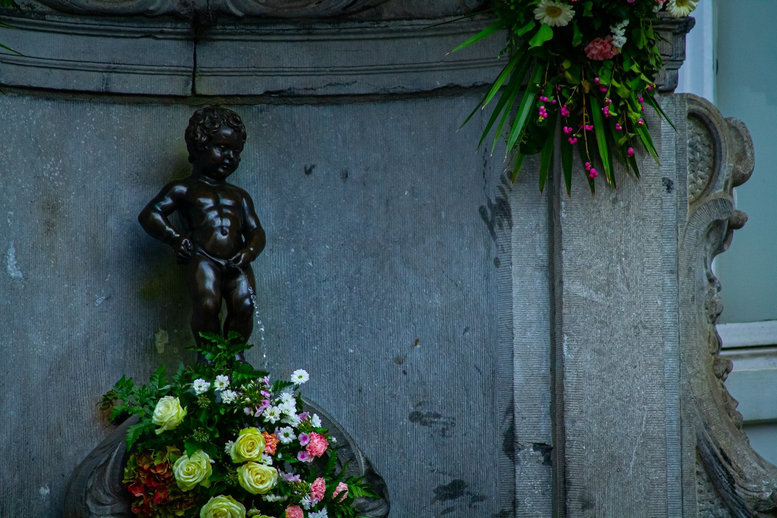 a statue of a boy holding a bouquet of flowers