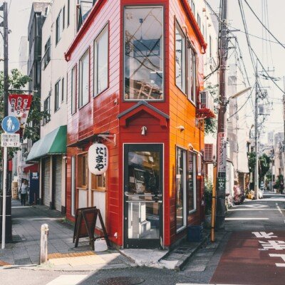 woman standing walking beside red building