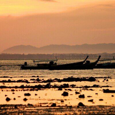white boat on sea during sunset