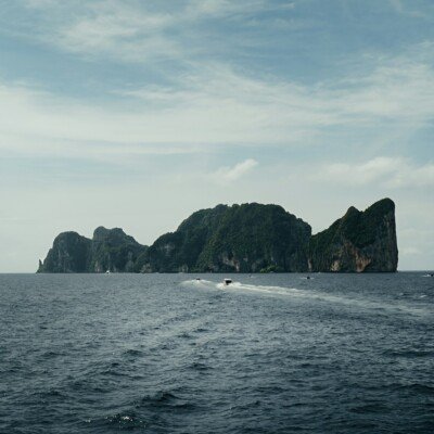 a boat is traveling through the water near some rocks