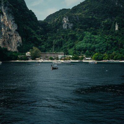 a boat in a body of water with mountains in the background