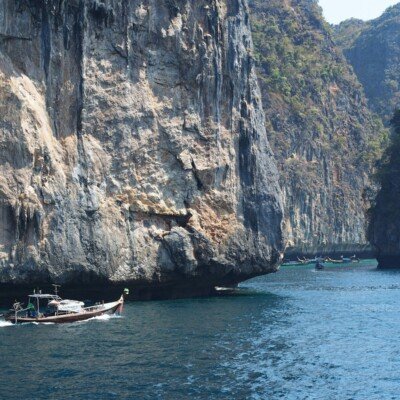 a boat traveling through a body of water near a mountain