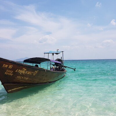 brown and white boat on sea under blue sky during daytime